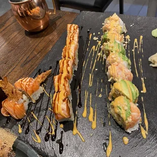 a variety of sushi on a slate platter
