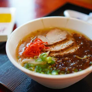 a bowl of ramen with meat and vegetables
