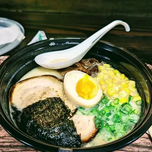 a bowl of ramen with an egg and a spoon