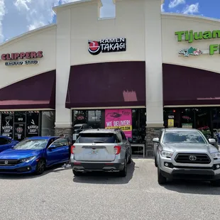the front of a restaurant with cars parked in front of it