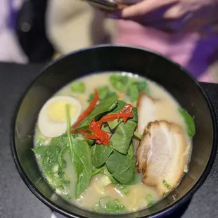 a bowl of ramen with meat and vegetables