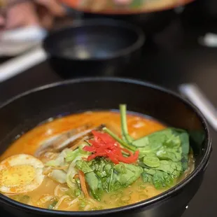 a bowl of ramen with eggs and spinach