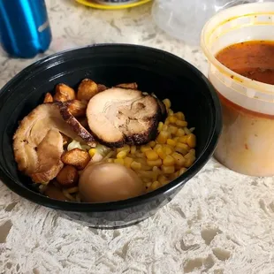 a bowl of ramen and a cup of soup