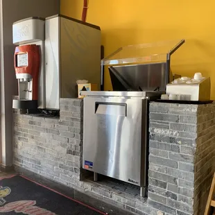 a kitchen with a stove, refrigerator, and sink