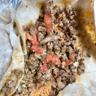 a burrito with meat and tomatoes