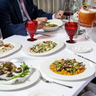 a woman sitting at a table with plates of food