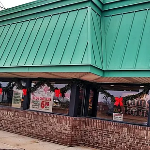 the front of a restaurant with a green roof