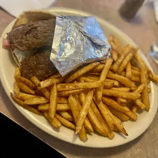 Gyro sandwich with seasoned fries, well done.
