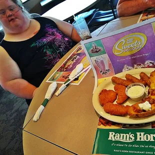 a woman sitting at a table with a plate of food