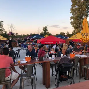people sitting at tables with umbrellas