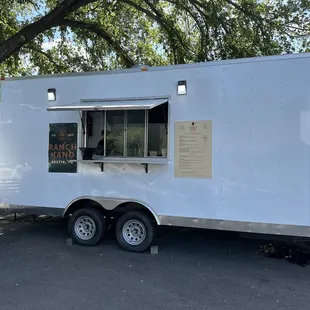 a white food truck parked in a parking lot