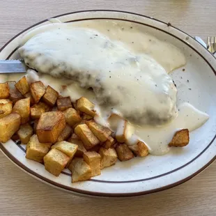 Country fried steak with gravy and diced potatoes