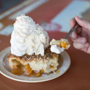 a hand holding a spoon with a scoop of ice cream on top