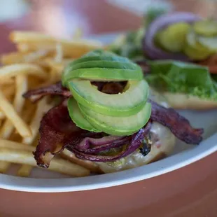 bacon, avocado, lettuce, tomato, and lettuce on a bun with french fries