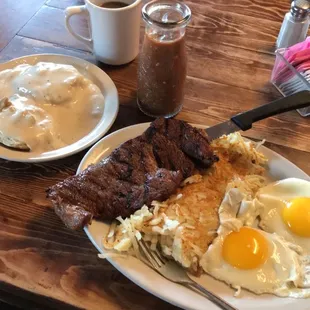 a plate of eggs, steak, and hash browns