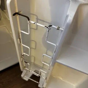 Fridge is rusty and paint chipping inside.