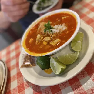 a bowl of soup and a plate of tortillas