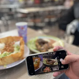 a person taking a picture of a plate of food