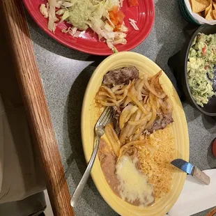 Asada plate with grilled onions along with beans and rice. Fresh guacamole with jalapeños!