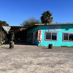 a turquoise building with pink trim