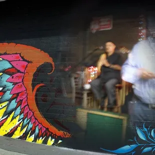 a man and woman in front of a mural