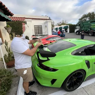 a man standing next to a green sports car