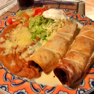 Beef chimichanga with refried beans and guacamole salad (salad is very watery)