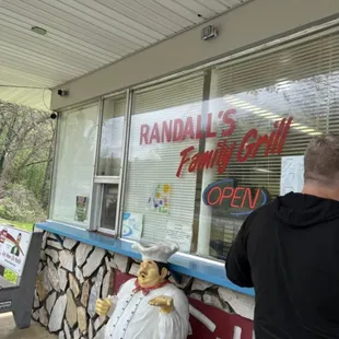 a man standing in front of a restaurant