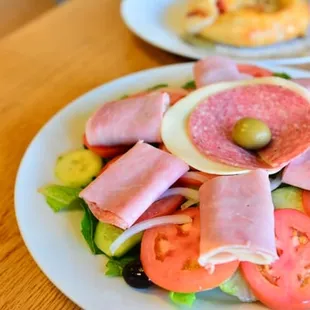 a salad with ham and tomatoes