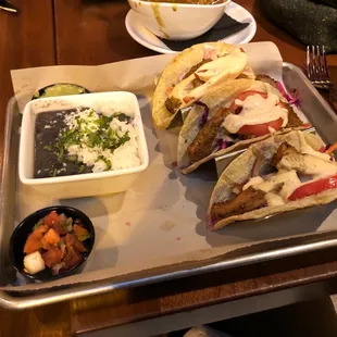 a tray of tacos and a bowl of salsa