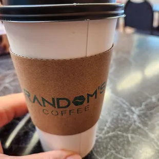 a hand holding a coffee cup