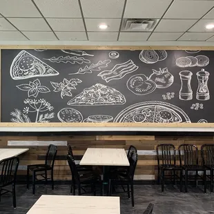 a man sitting at a table in front of a chalkboard