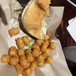 Half eaten cheeseburger and tots