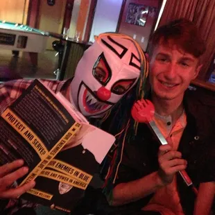 a man in a clown mask holding a book and a knife