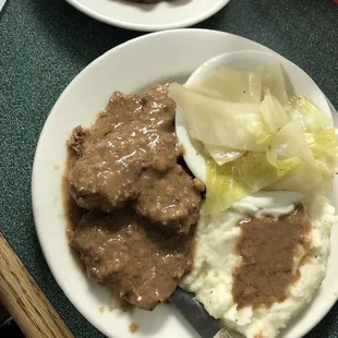 Country style steak with fried okra, mashed potatoes, and cabbage