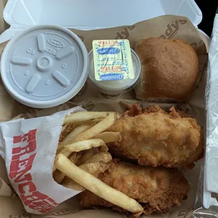 Chicken strips, baked beans, roll, and fries.