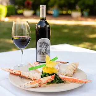 a plate of crab legs and a glass of wine