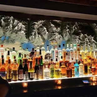 bottles of alcohol lined up on a bar