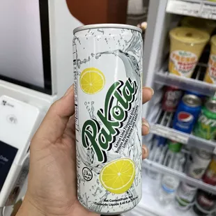 a person holding a can of lemonade