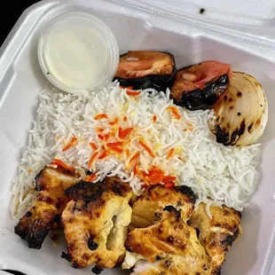 chicken, rice, and vegetables in a styrofoam container