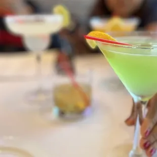a person holding a glass of green drink