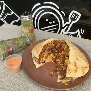 a burrito with a side of salsa