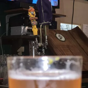 a pint of beer in front of a television