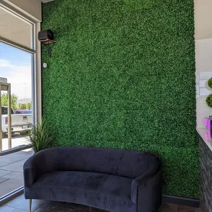 a couch in front of a green wall