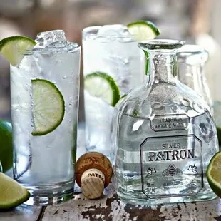 a bottle of silver patron with limes and corks