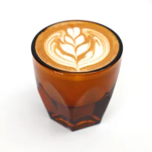 a glass with a latte art on it