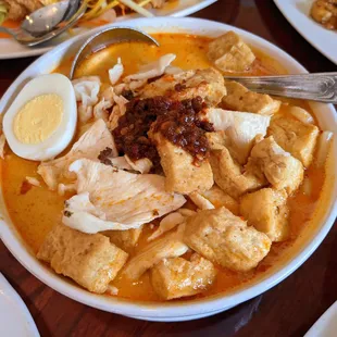 Laksa with chicken. Udon noodles, tofu, bean sprouts, and egg in coconut-spiced soup. $14.95.