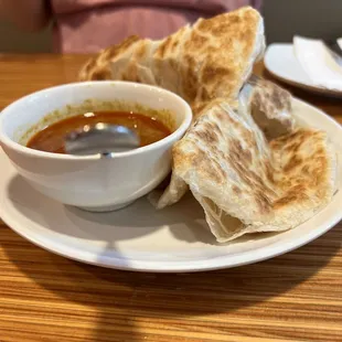 a bowl of soup and pita bread