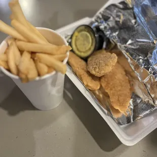 a container of french fries and a container of chicken nuggies