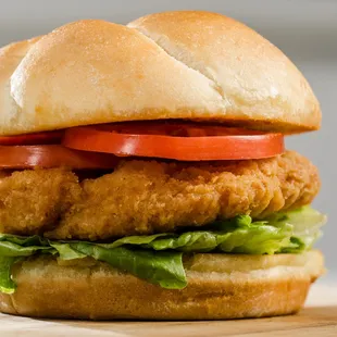 a chicken sandwich with lettuce and tomatoes